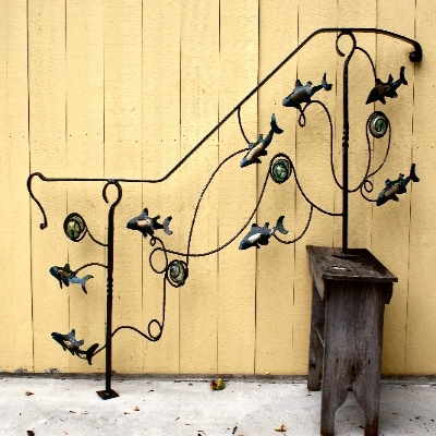 Wrought iron railing with swimming fish and glass floats.